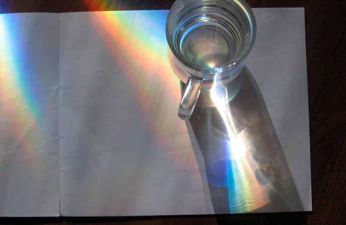 Arco iris formado por el paso de la luz a través de un vaso de agua